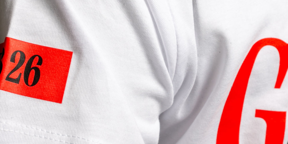 Nahaufnahme eines weißen T-Shirts mit rotem Aufdruck – individuelle Textilveredelung von TEXTIL.Team